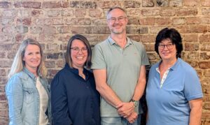 Auf dem Foto sieht man das Team vom Komm Webshop. Von links nach rechts Frau Menke, Frau Scharmann, Herr Siefert, Frau Patzwald